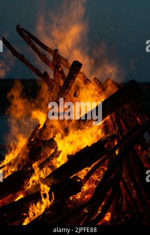 Eine vertikale Aufnahme brennender Wälder bei einem Lagerfeuer in der Nacht Stockfoto