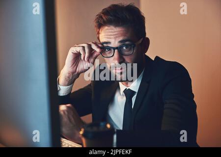 Erfolg passiert nicht 9-5. Ein Porträt eines hübschen jungen Geschäftsmannes, der spät im Büro arbeitet. Stockfoto