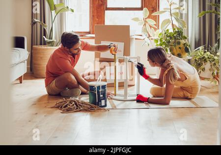 Paar Malerei Holztisch durch Recycling, spenden und Sparsamkeit Möbel für ein neues Haus Verbesserung Projekt in neue Wohnung. Kreativ und DIY Mann und Stockfoto