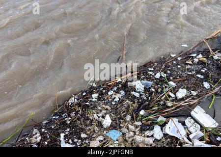 Überschwemmen Sie Trümmer und schlagen Sie im Fluss Stockfoto