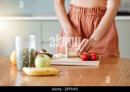 Frau, die einen gesunden Smoothie für Energie, Ernährung und Wellness zubereitet, indem frische Bio-Früchte geschnitten, geschnitten und zubereitet werden. Köstliches Detox-Getränk Stockfoto