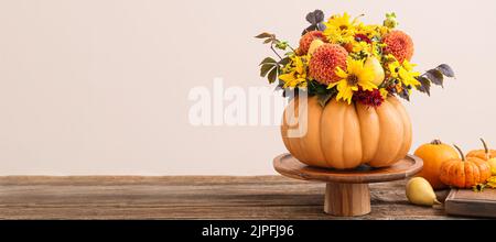 Schöner Herbststrauß in Kürbis auf Tisch vor hellem Hintergrund. Banner für Design Stockfoto