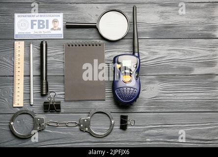 Zubehör des FBI-Agenten auf dunklem Holzhintergrund Stockfoto