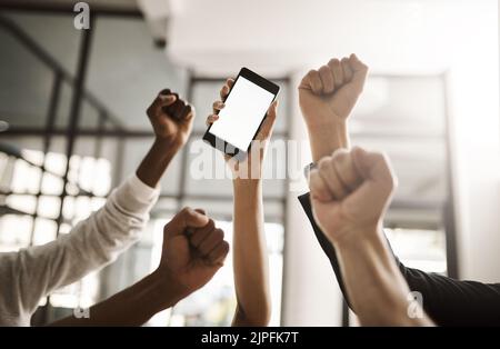 Geschäftsleute jubeln und feiern gute Nachrichten auf einem Telefon mit leerem Bildschirm für den Kopierbereich. Begeistertes Team von Büromitarbeitern, das Macht zeigt Stockfoto
