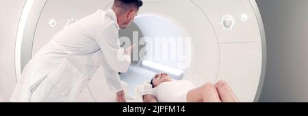 Der Radiologe des medizinischen Labors kontrolliert den MRT-CT-Scan des Patienten, der sich einem Eingriff unterziehen muss Stockfoto