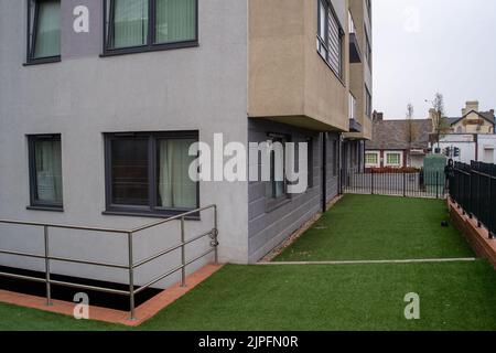 Slough, berkshire, Großbritannien. 17.. August 2022. Gefälschtes Gras vor einem Apartmentblock in Slough hinterlässt eine fade, wildlebende Umgebung. Quelle: Maureen McLean/Alamy Stockfoto