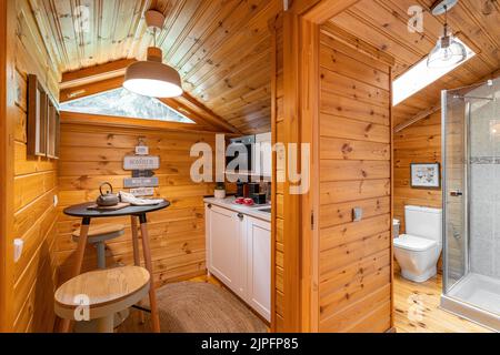 Kompakte Küche mit kleinem Bad im Holzhaus. Dorfleben Konzept. Stockfoto