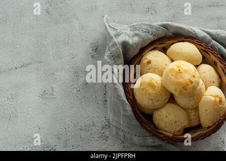 Korb mit Käsebrot oder Käsebun auf Steintisch Stockfoto