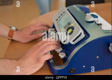 Blinder Mann mit Brailleschrift-Schreibmaschine. Stockfoto