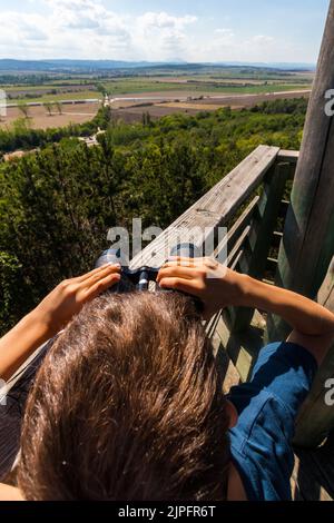 Kind schaut durch ein Fernglas auf dem Aussichtsturm Hubertus nach Südwesten, Sopron, Ungarn Stockfoto