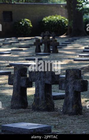 LANGEMARK, BELGIEN - 10. AUGUST 2022: Steinkreuze und flache Grabsteine auf dem deutschen Friedhof Stockfoto