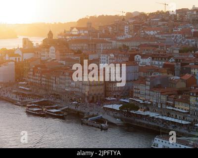 Erhöhte Aussicht auf das Ribeira Flussufer Viertel und den Douro Fluss in Porto, Portugal. Die Boote liegen im Hafen vor Anker. Stockfoto