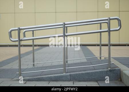 Stahlhandlauf für wenige mobile Menschen. Architekturdetails. Heben Sie den Kinderwagen an. Komfortable städtische Umgebung. Stockfoto