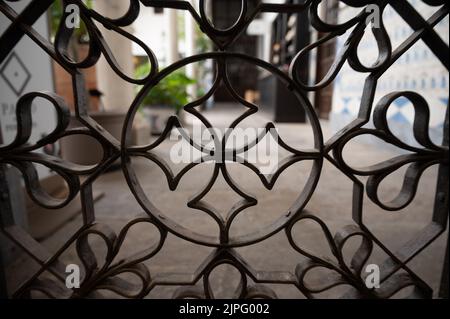 Beispiel für mittelalterliche maurische symmetrische und geometrische Ornamente an Eisentüren in Granada, Andalusien, Spanien Stockfoto