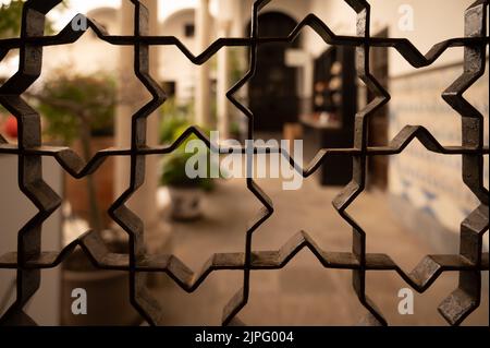 Beispiel für mittelalterliche maurische symmetrische und geometrische Ornamente an Eisentüren in Granada, Andalusien, Spanien Stockfoto