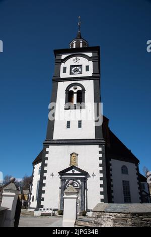 Eine achteckige, weiß getünchte Steinkirche wurde 1784 in Røros, einer Bergbaustadt mit historischen Holzgebäuden in Mittelnorwegen, erbaut. Stockfoto