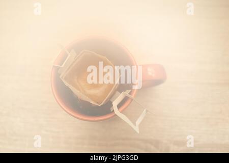 Kaffee tropft in die Tasse. Alternativer Kaffee für die Zubereitung von Spezialkaffee in Papierfiltertüten. Stockfoto