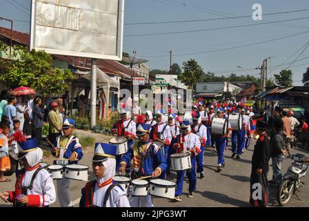 Tegal, INDONESIEN, 3. Mai 2018 - Eine Gruppe von Marschkapelle zieht in blauer Uniform einen langen marsch durch die Straßen des Dorfes Stockfoto