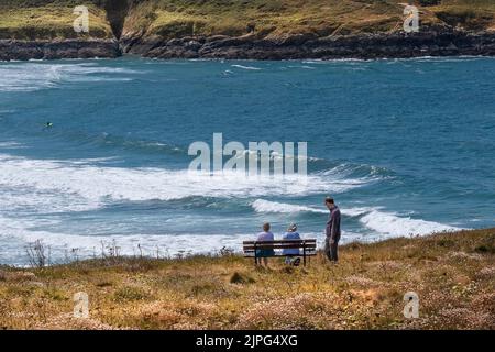 Menschen, die sich entspannen und die Aussicht vom Pentire Point East an der Küste von Newquay in Cornwall in Großbritannien genießen. Stockfoto