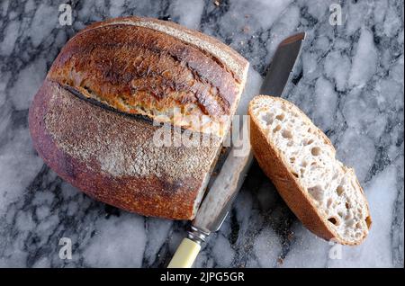 Handgemachtes Sauerteig-Brot auf Marmorplatte Stockfoto