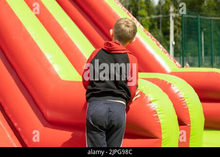 Kind auf Hindernisparcours. Kind im Vergnügungspark. Ruhe im Sommer. Aktiver Lebensstil. Stockfoto