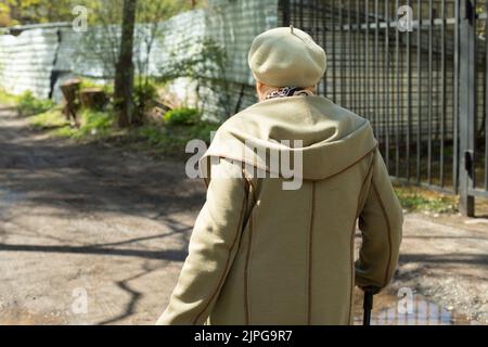 Der Rentner geht die Straße runter. Großmutter in Russland. Frau mit Gehstock. Älterer Mann in der Stadt. Stockfoto