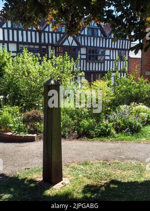 Holzdenkmal im Walled Garden mit Church House hinter Ledbury Herefordshire England Stockfoto