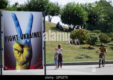 Kiew, Ukraine. 17. August 2022. Die Menschen ruhen im Park in der Nähe der Plakatausstellung mit dem Titel „Tag des Sieges“ im Nationalmuseum für Geschichte der Ukraine im Zweiten Weltkrieg in Kiew. Die Plakate des ukrainischen Malers Andrii Yarmolenko und des polnischen Künstlers Wojciech Korkuts reflektieren vor allem den russischen Einmarsch in die Ukraine mit der Hoffnung auf den Sieg der Ukraine gegen die russische Armee. Kredit: SOPA Images Limited/Alamy Live Nachrichten Stockfoto