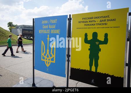 Kiew, Ukraine. 17. August 2022. Die Menschen gehen an einer Plakatausstellung unter dem Titel „Tag des Sieges“ im Nationalmuseum für Geschichte der Ukraine im Zweiten Weltkrieg in Kiew vorbei. Die Plakate des ukrainischen Malers Andrii Yarmolenko und des polnischen Künstlers Wojciech Korkuts reflektieren vor allem den russischen Einmarsch in die Ukraine mit der Hoffnung auf den Sieg der Ukraine gegen die russische Armee. Kredit: SOPA Images Limited/Alamy Live Nachrichten Stockfoto