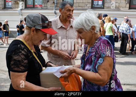 Saporischschschja, Ukraine. 15. August 2022. An einem Verteilungspunkt für humanitäre Hilfe in Saporischschschja erhalten die Menschen Kisten mit Nahrungsmittelhilfe. Seit Beginn der russischen Invasion wurde fast ein Drittel der Ukrainer aus ihren Häusern gezwungen. Dies ist laut dem UN-Flüchtlingshilfswerk eine der größten Vertreibungskrisen weltweit. Die Menschen in den unmittelbar von Konflikten betroffenen Gebieten benötigen dringend lebensrettende Unterstützung, es fehlt ihnen an Nahrungsmitteln, Energie und Versorgungseinrichtungen und sie stehen vor einem Zusammenbruch der Bereitstellung grundlegender Dienstleistungen. Sie sind auch mit dem Risiko von Umweltkatastrophen aufgrund von Prox konfrontiert Stockfoto