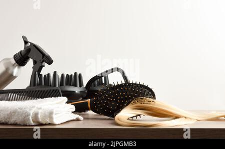 Friseurzubehör auf weißer Werkbank im Friseursalon mit Fenster im Hintergrund. Vorderansicht. Horizontale Zusammensetzung. Stockfoto