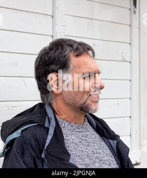 Mann mit Bart und grauen Haaren, mit rustikalem weißen Hintergrund Stockfoto