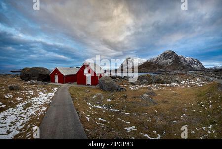 Hütten auf Haramsøya mit Windkraftanlagen auf dem Gipfel des Berges, Ålesund, Møre Og Romsdal, Norwegen. Stockfoto