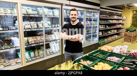 Hamburg, Deutschland. 18. August 2022. Geschäftsführer Fabian Winnersteht in Hamburgs erstem Supermarkt ohne Kasse, wie er behauptet. Die Videotechnologie weist Personen anonym Produkte zu, wenn sie etwas verpacken. Wenn sie den Store verlassen, werden sie automatisch über die App abgerechnet. Quelle: Markus Scholz/dpa/Alamy Live News Stockfoto