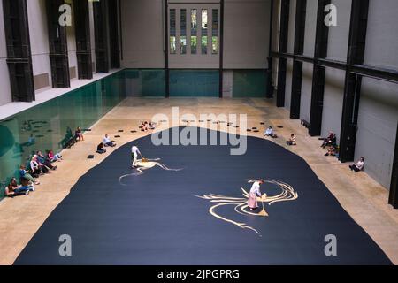 Künstler in traditioneller Kleidung schieben Reis mit Besen in einer Arbeit mit dem Titel „labyrinthisch“ des Künstlers Lee Mingwei. In der Haupthalle des Kraftwerks b Stockfoto