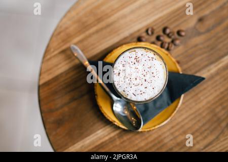 Ein Artisan Specialty Short Black Coffee mit geschäumter Milch und Kaffeebohnen Stockfoto