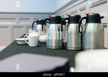 Ein Konferenzzimmertisch mit Kaffee- und Teethermosen Stockfoto