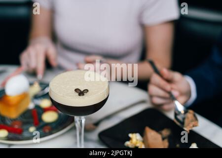 Pärchen, die Espresso Martini-Cocktails zu ihrem Nachtisch trinken Stockfoto