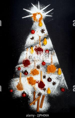 Weihnachtsbaum aus verschiedenen Gewürzen, Holzlöffeln und Zuckerpulver, Flat Lay kreatives Konzept Stockfoto