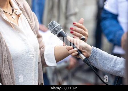 Reporter macht Medien oder Vox Pop Interview mit unkenntlich weibliche Person Stockfoto