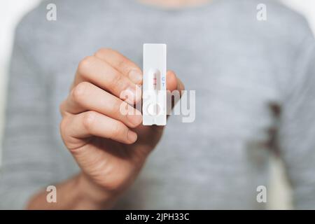 Ein positiver, schneller, auf dem Zuhause basierender Coronavirus-Test, der eine Infektion zeigt Stockfoto