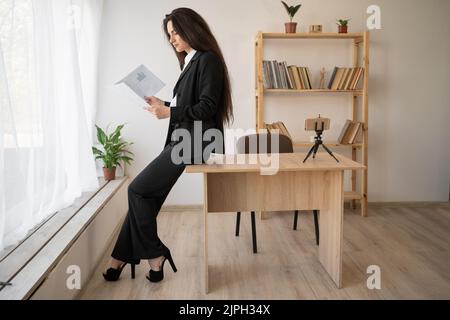 Stilvolle Geschäftsfrau lesen Papiere oder Steuerbericht im Büro. Business, Finanzen und Menschen Stockfoto