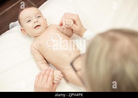 Weibliche Masseur tun Baby-Massage für Fuß kleines Kleinkind Baby Kind Stockfoto