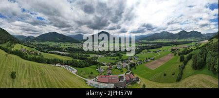 Ein Luftpanorama von einem Hügel mit Wald und Häusern in den Ausläufern Stockfoto