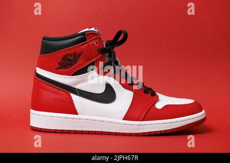 Das rechte Paar des Air Jordan 1 Chicago isoliert auf einem roten Hintergrund. Stockfoto