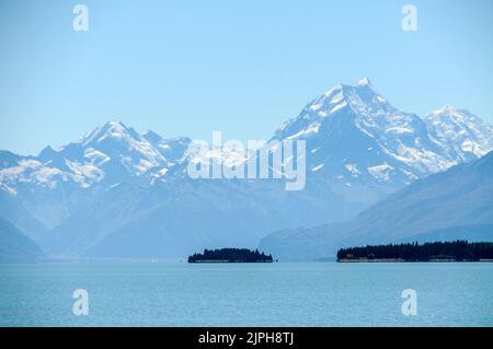 Die weit entfernten schneebedeckten Gipfel des Aoraki/ Mt Cook, der Mt Cook Nationalpark in den Südalpen und der von Gletschern gespeiste türkisfarbene Lake Tekapo in Stockfoto