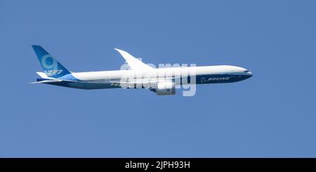 Seattle - 14. August 2022; Seitenansicht einer neuen 777X im Flug, die sich gegen einen blauen Himmel wendet Stockfoto