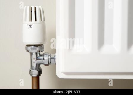 Ecke eines Heizkörpers mit dem Temperaturventil Stockfoto