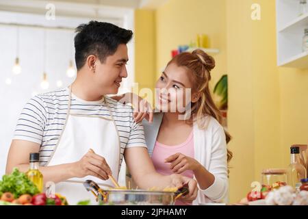 Junger vietnamesischer Mann kocht Spaghetti für seine Freundin Stockfoto