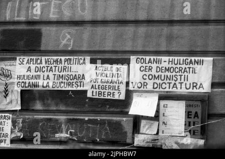 Bukarest, Rumänien, April 1990. „Golaniada“, ein großer Anti-Kommunismus-Protest auf dem Universitätsplatz nach der rumänischen Revolution von 1989. Die Menschen versammelten sich täglich, um gegen die Ex-Kommunisten zu protestieren, die nach der Revolution die Macht ergriffen hatten. Am Universitätsgebäude hingen verschiedene Plakate. Stockfoto